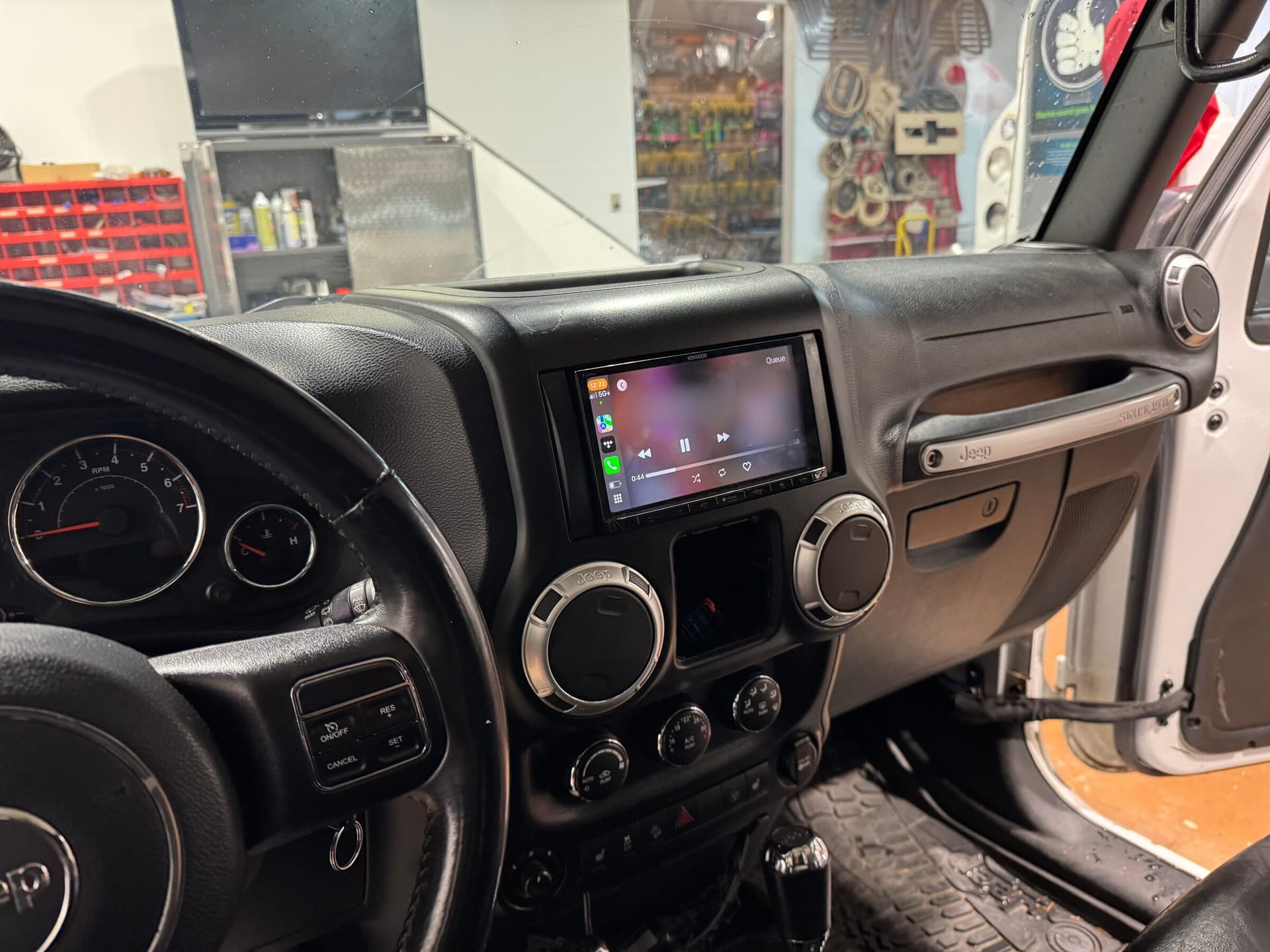 Kenwood touchscreen running Apple CarPlay in a Jeep Wrangler dashboard